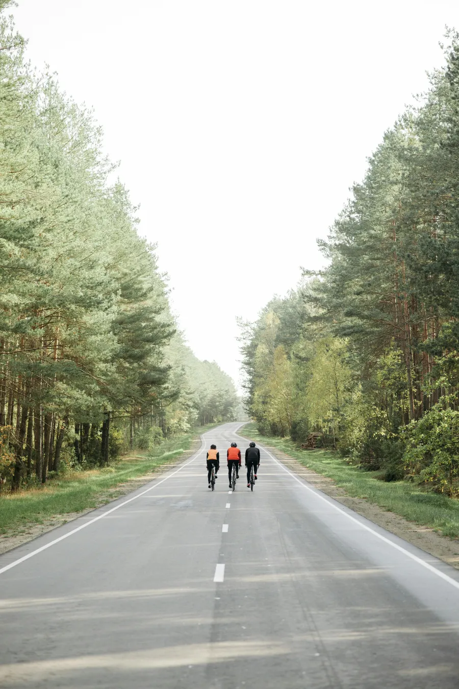 Three cyclists riding together on a quiet road