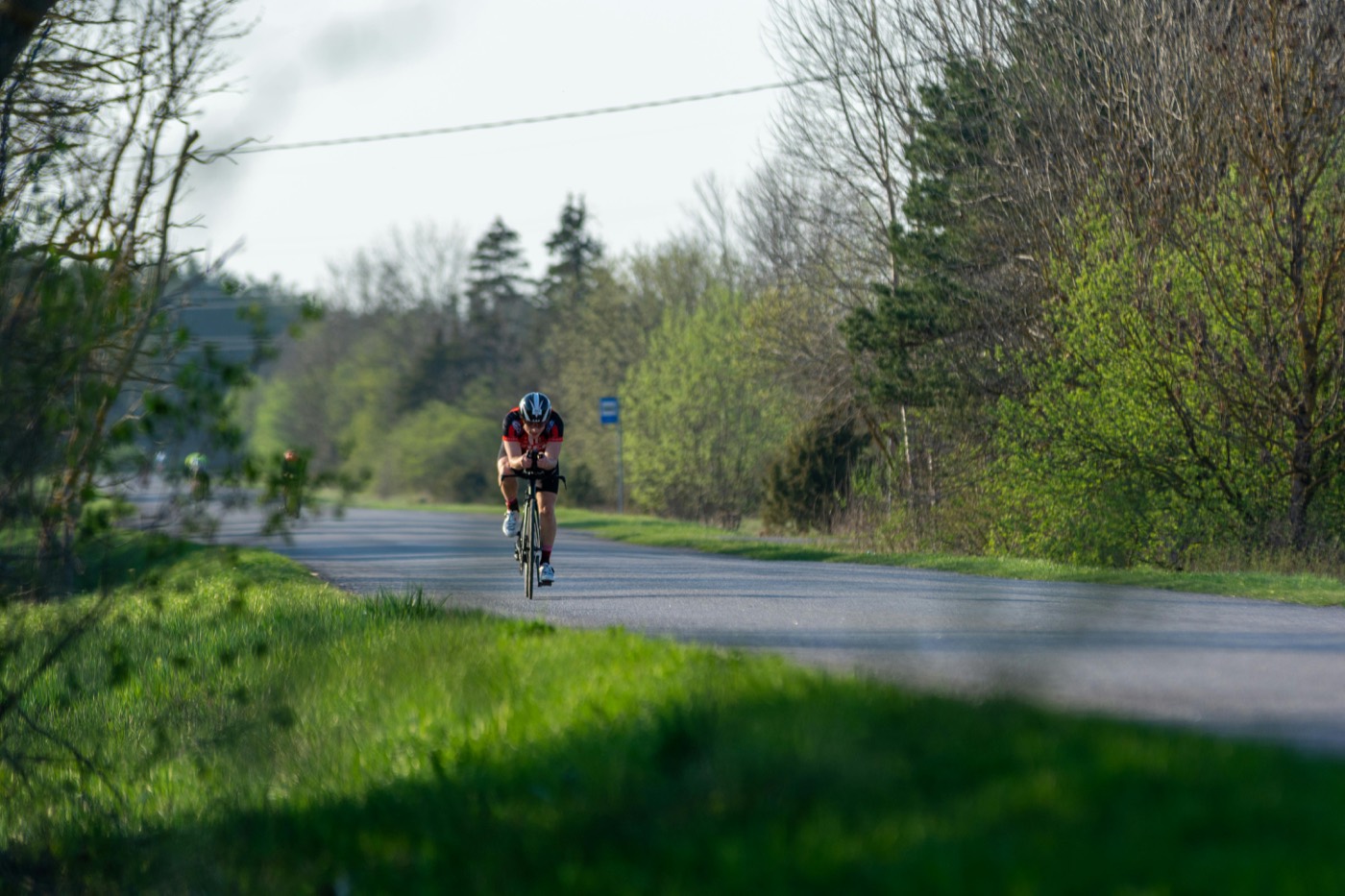 A triathlete riding alone on an open road